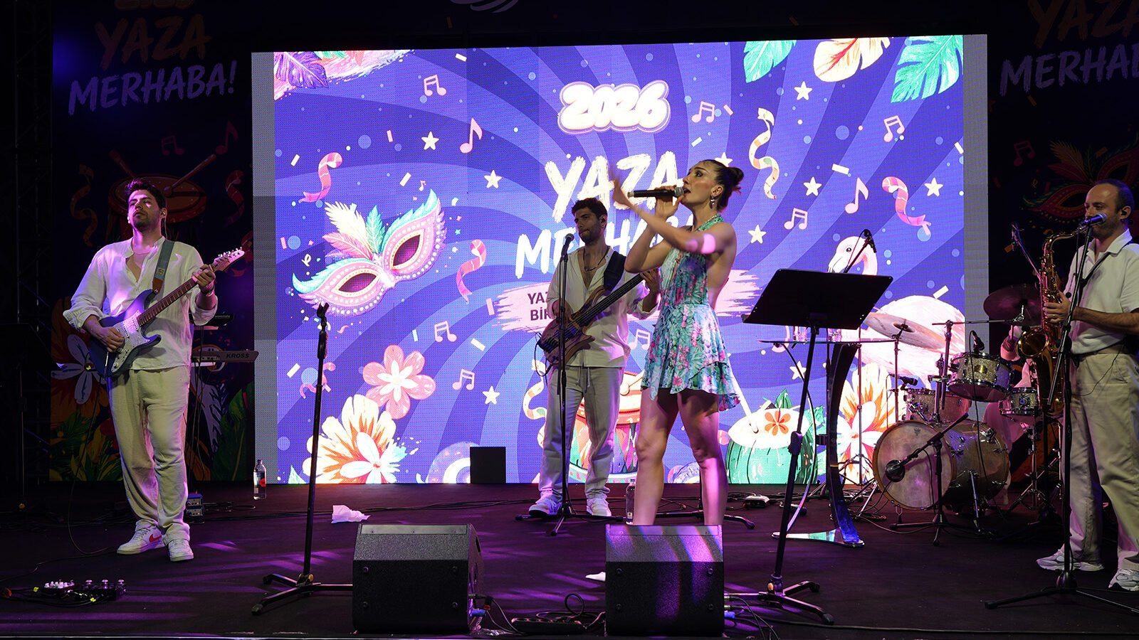 Festival sahnesi, ışık kulesi ve seyirci alanını temsil eden soyut görsel